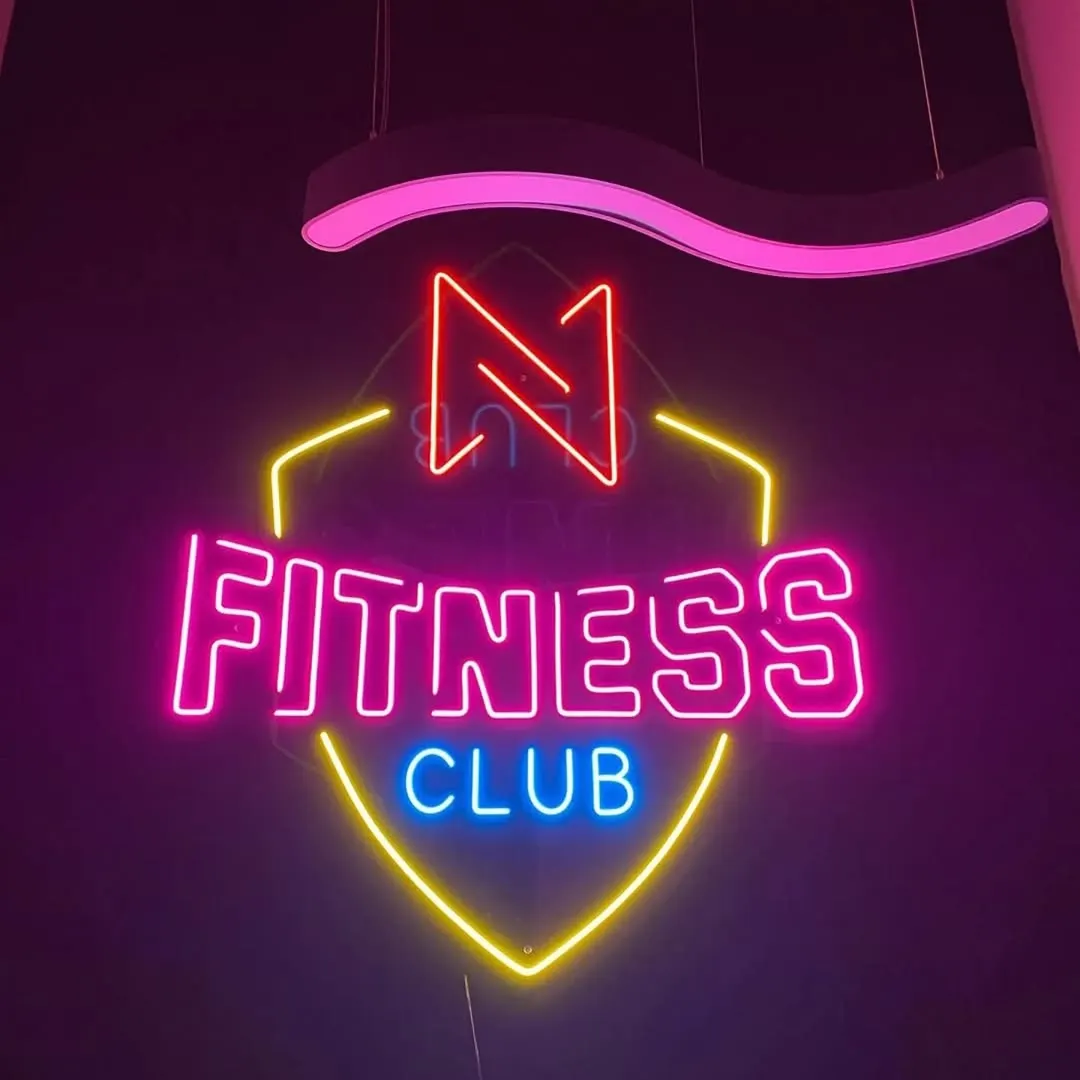 Pembe, sarı ve mavi tonlarda kalkan biçiminde fitness kulübü logo neonu